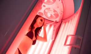 Woman enjoying a rejuvenating red light therapy session in SunScape Tanning's Beauty Angel booth